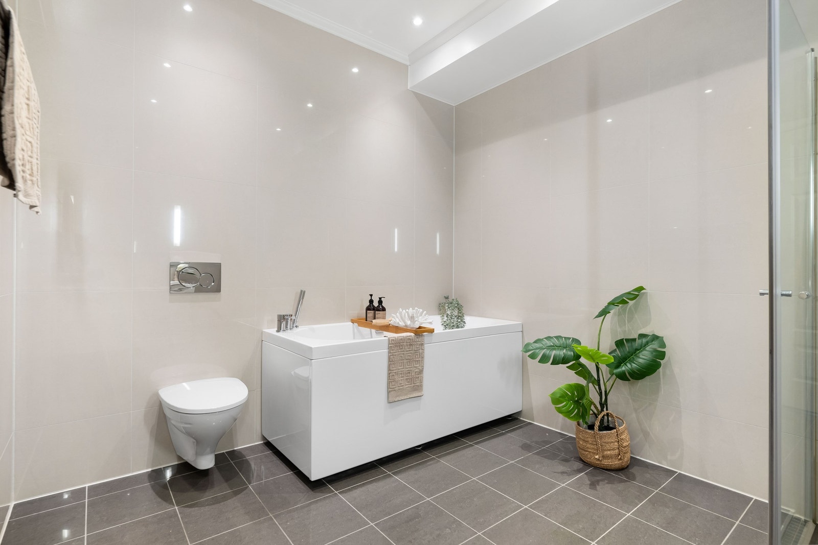 Badet er helfliset med gulvvarme og innredet med baderomsmøbler med dobbel vask, vegghengt wc og både dusjhjørne og badekar Galleribilde