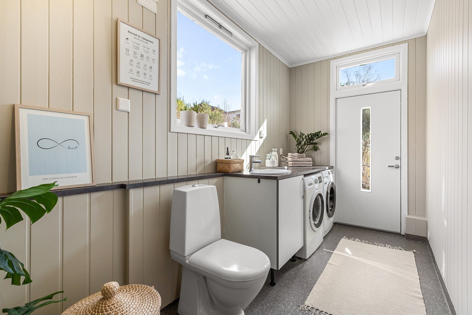 I trappen er det dør inn til et separat vaskerom med opplegg for vaskemaskin og tørketrommel i benkeinnredning. Praktisk inn/utgang fra vaskerom og til hagen. Galleribilde