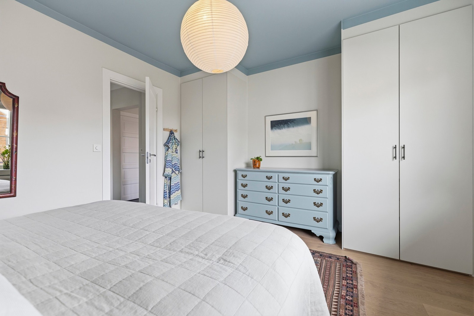 Her er det innredet med garderobeskap som gir praktisk oppbevaringsplass for klær og sengetøy, og bidrar til et ryddig og organisert rom. Galleribilde