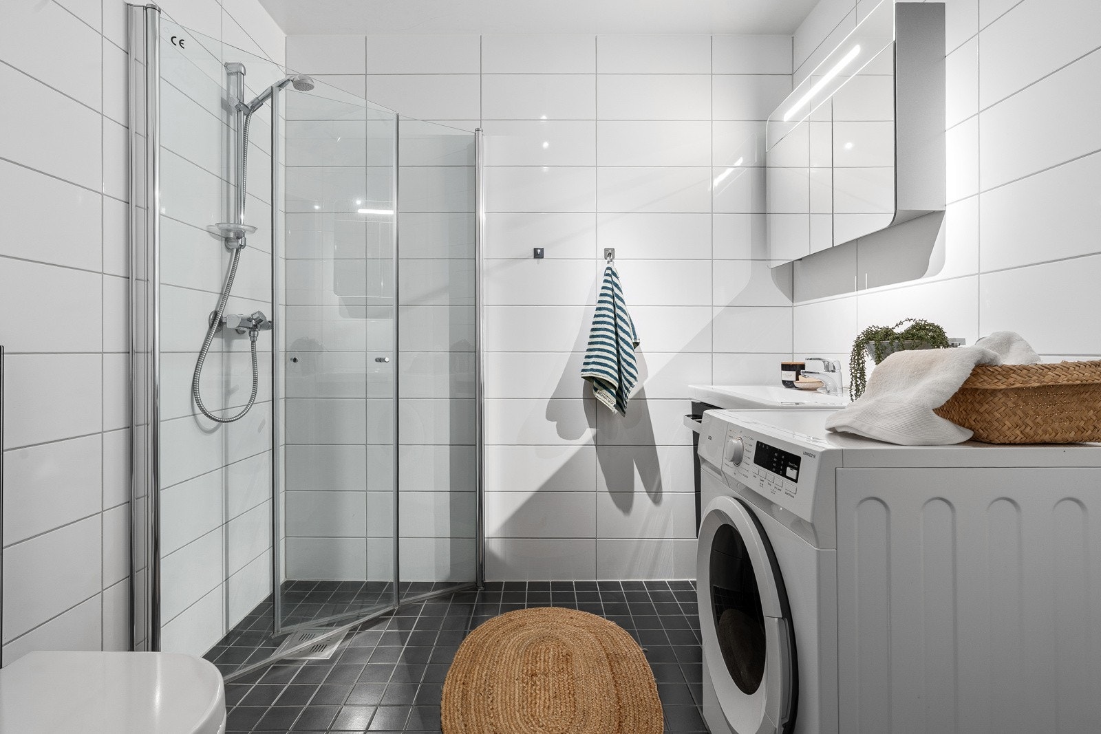 Delikat og moderne bad med praktiske løsninger som dusjhjørne med innfellbare dører og vegghengt toalett. Galleribilde