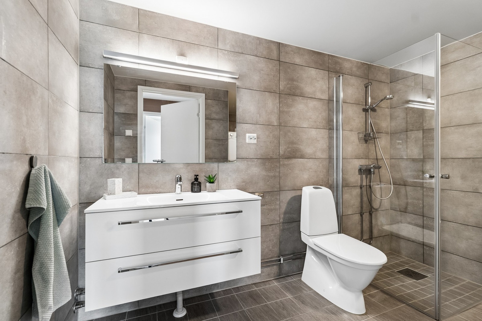 Boligens bad har en moderne og svært pen utførelse med tidsriktige farge- og materialvalg på overflater, og en lys baderomsinnredning som gjør at badet gir et tidløst inntrykk. Galleribilde