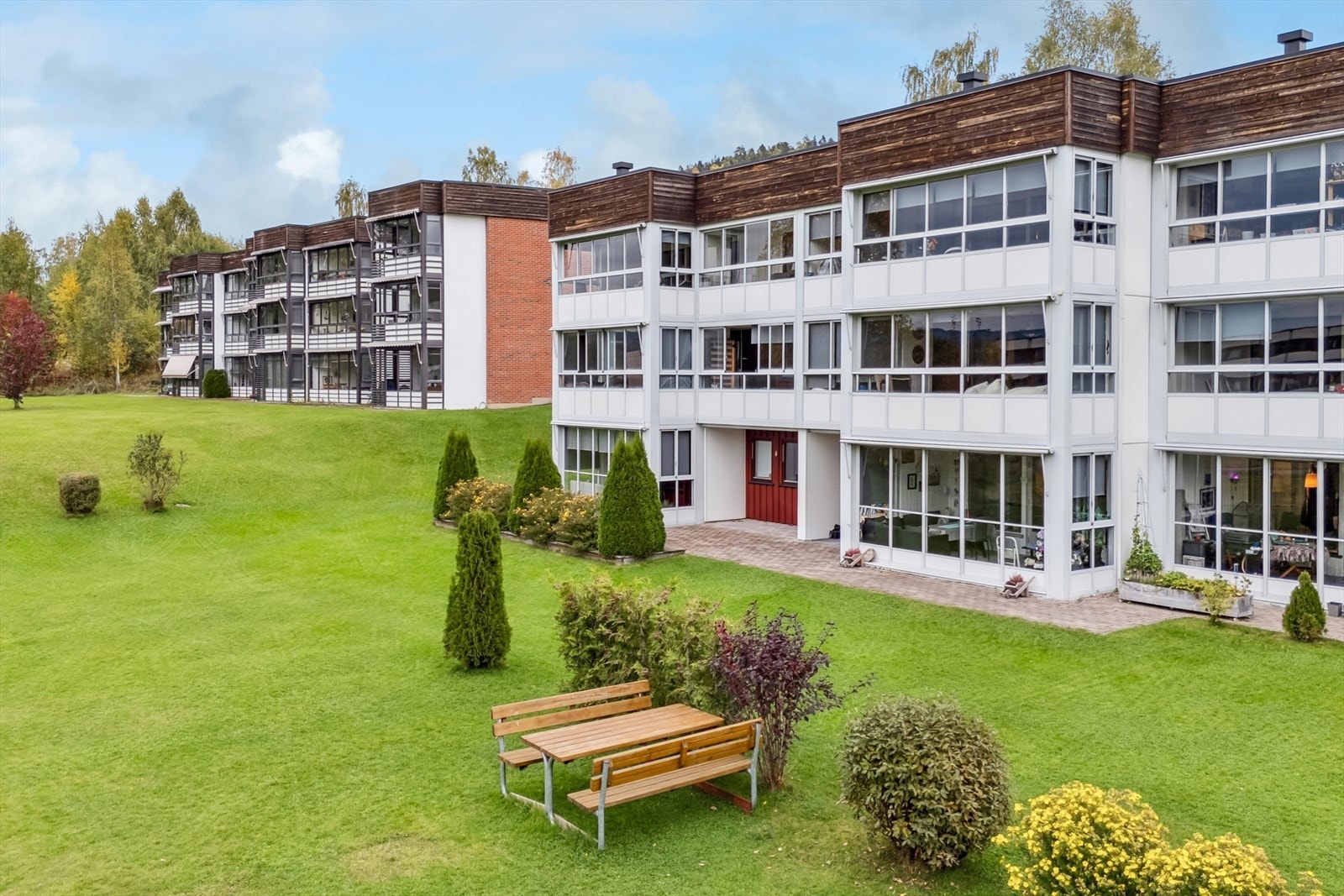 Bygget er omgitt av en stor, felles tomt på 2421 m² med plen og beplantning. Galleribilde