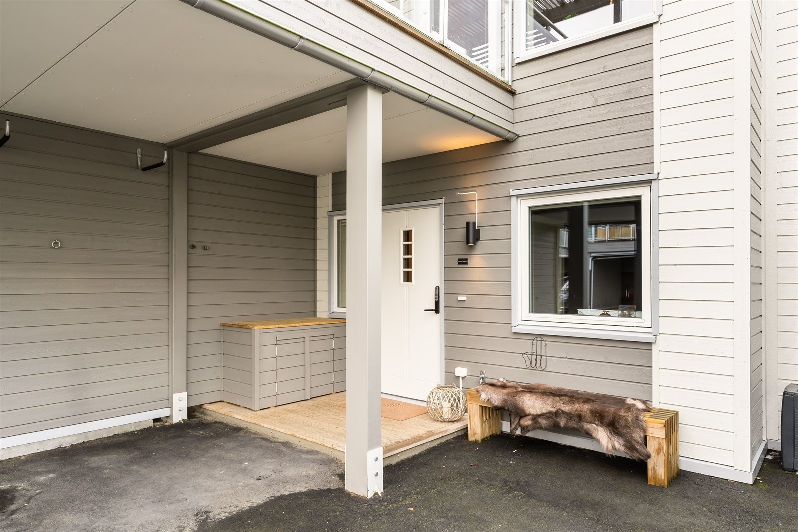 Inngangspartiet ligger innerst i carporten og har en ytterdør med glassfelt, sidevindu og kodelås. Galleribilde