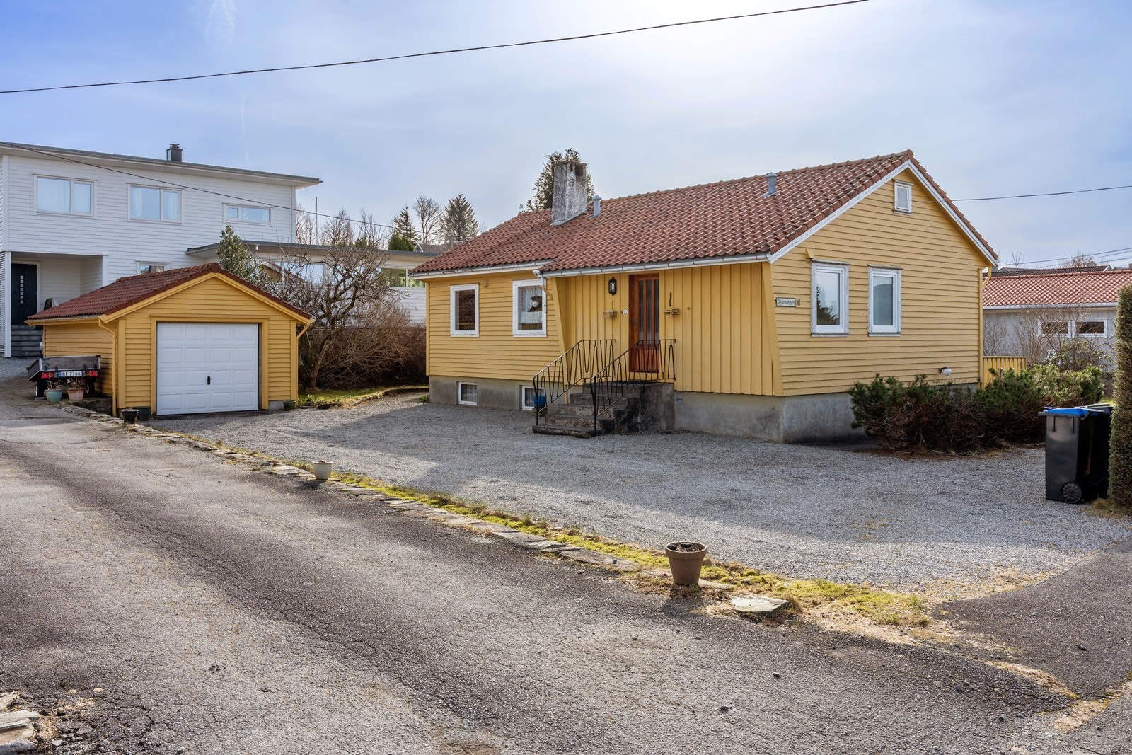Gruset gårdsplass med meget gode parkeringsmuligheter og garasje med plass til en bil Galleribilde