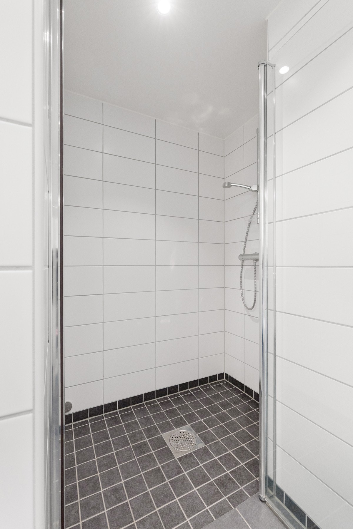 Badet er utstyrt med toalett, servantinnredning og dusjhjørne. Galleribilde