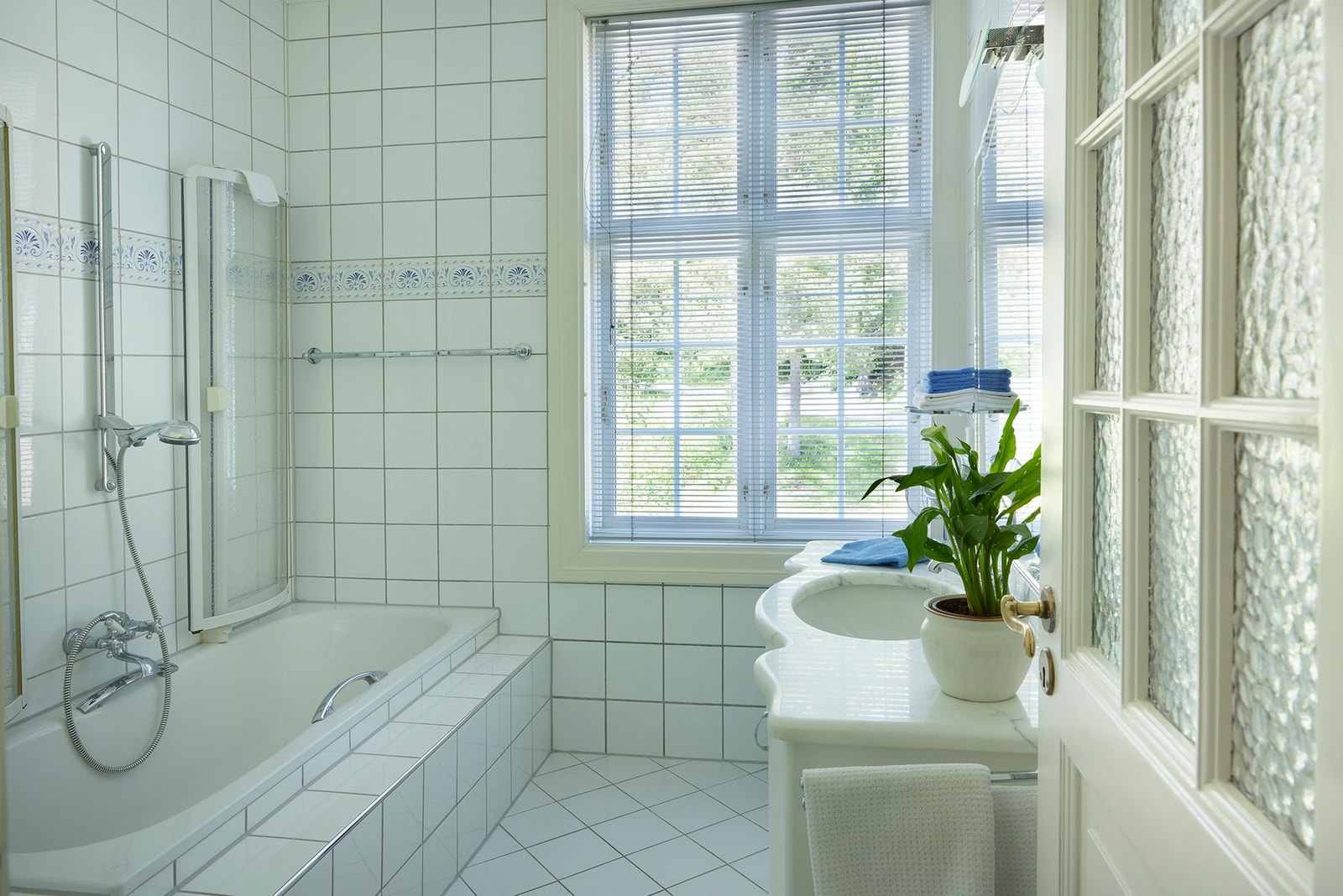 Hovedbad fra 1990-tallet med flislagte overflater, varmekabler i gulv og innredning fra 1995/96. Badet har badekar med dusjløsning, WC og servant i hvitt porselen, samt malt himling, håndklevarmer og ventilasjon via himling. Galleribilde