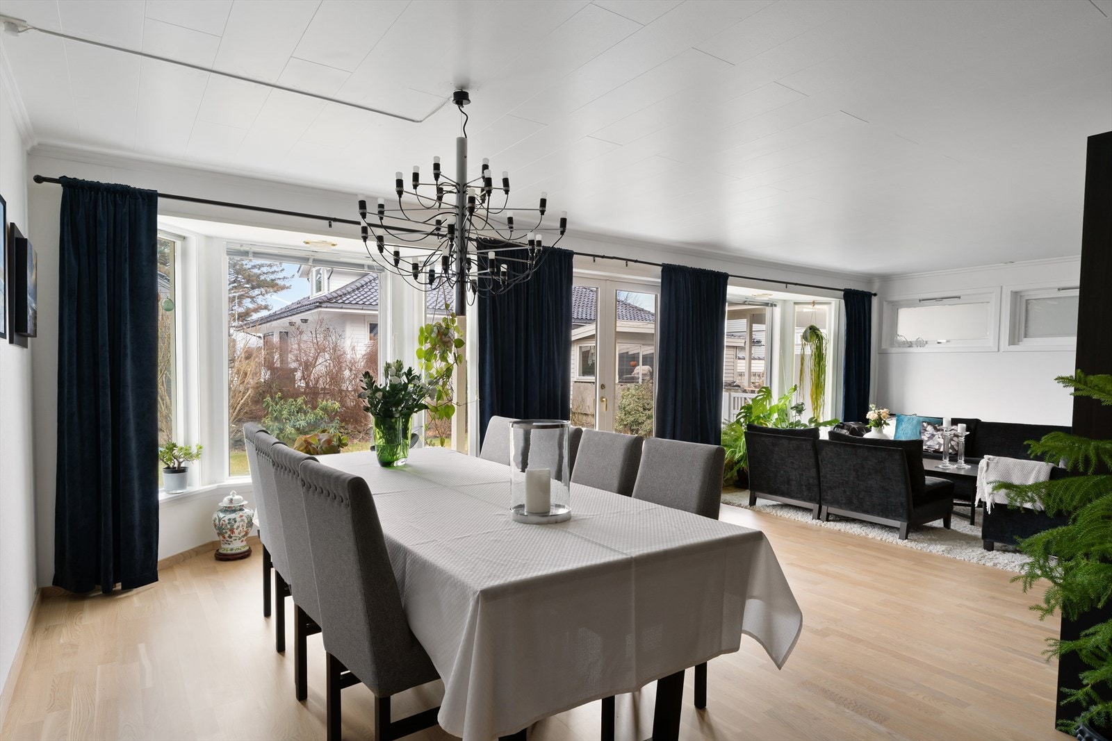 Stue med parkett på gulv, flott peisovn, gode vindusflater og utgang til terrasse og hage. Galleribilde