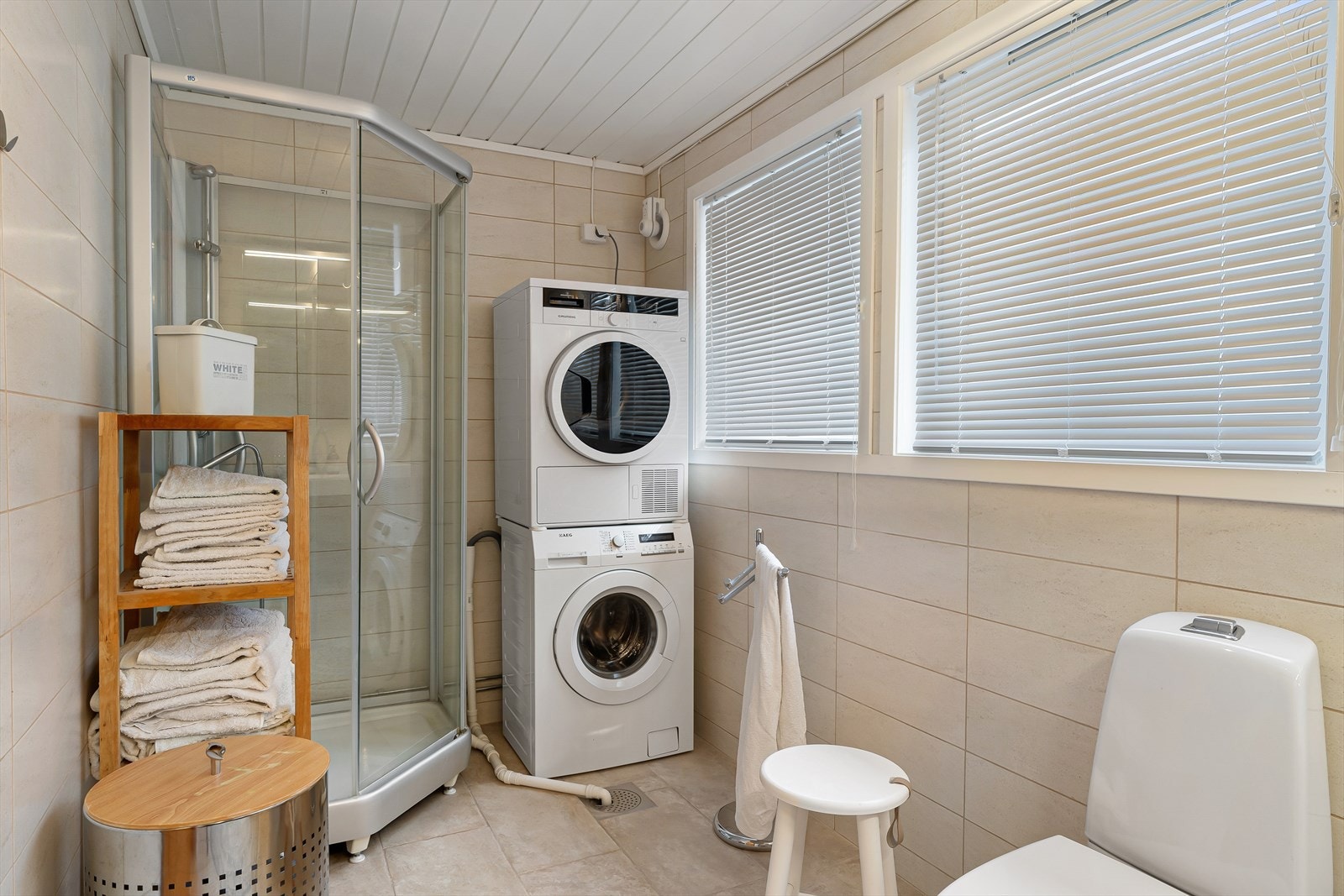 Flislagt bad med gulvvarme. Innredet med dusjkabinett, wc og dobbel vask. Opplegg for vaskemaskin og tørketrommel. Galleribilde