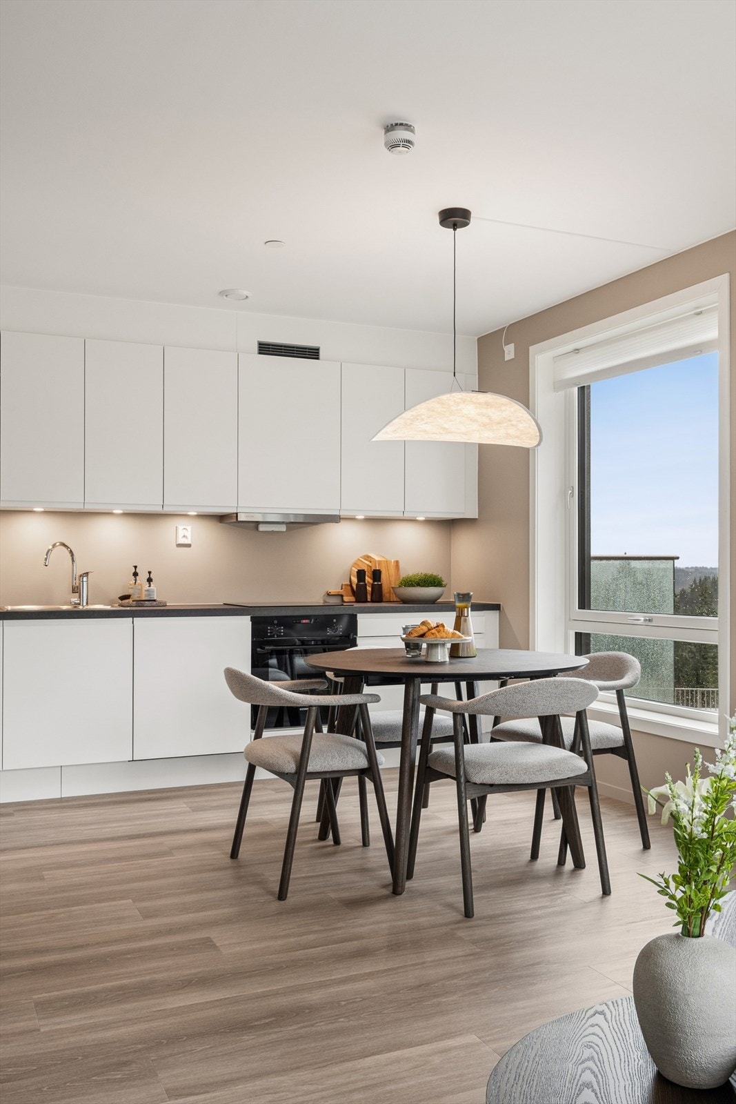 Innredningen består av hvite, glatte fronter og en laminert benkeplate med nedfelt vask i rustfritt stål. Galleribilde