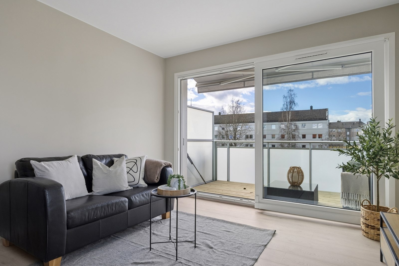 Stuen har plass til både sofagruppe og spisebord. Skyvedøren fra 2008 åpner opp mot balkongen. Galleribilde