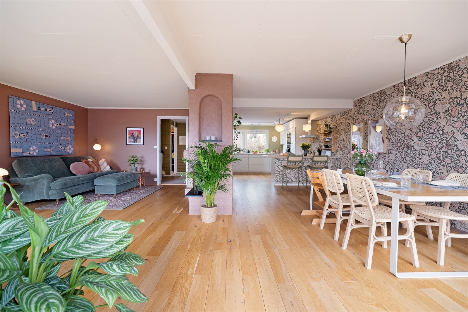 Halvveggen skaper en naturlig avgrensning mellom stue og kjøkken, uten å stenge ute lys og romfølelse Galleribilde