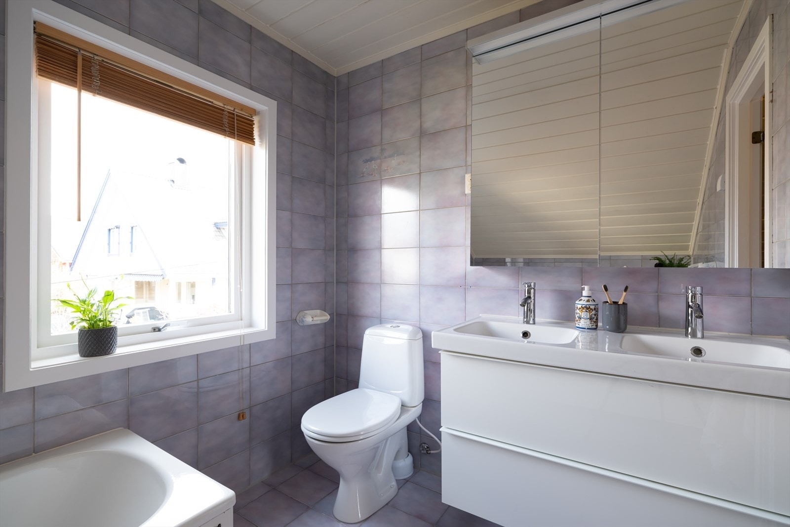 Badet har flislagte vegger og gulv, samt malte panel i himling Galleribilde