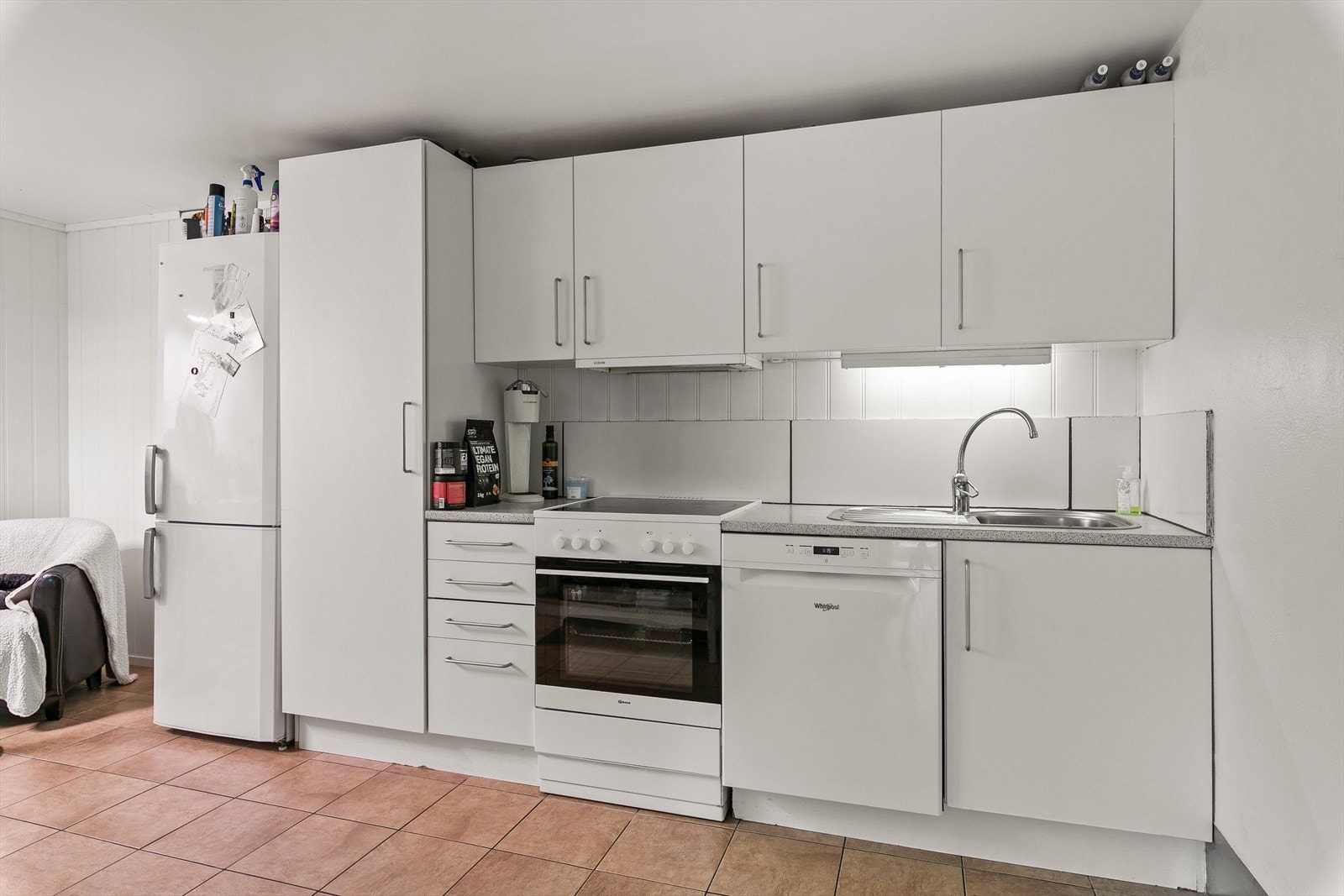 Kjøkkenet har en innredning med slette, hvite fronter og laminert benkeplate. Galleribilde