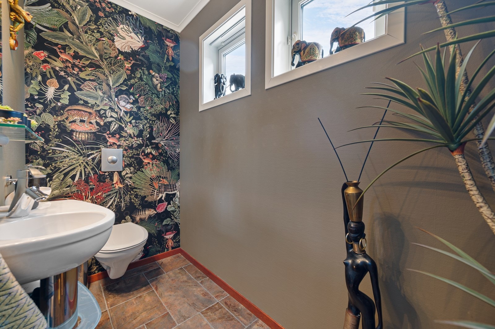 Toalettrommet har fliser på gulv og tapet på vegger. Galleribilde