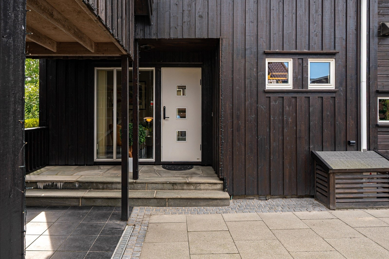 Ved inngangspartiet er det en romslig, steinbelagt gårdsplass med lyse belegningsstein og dekorative mønstre. Galleribilde