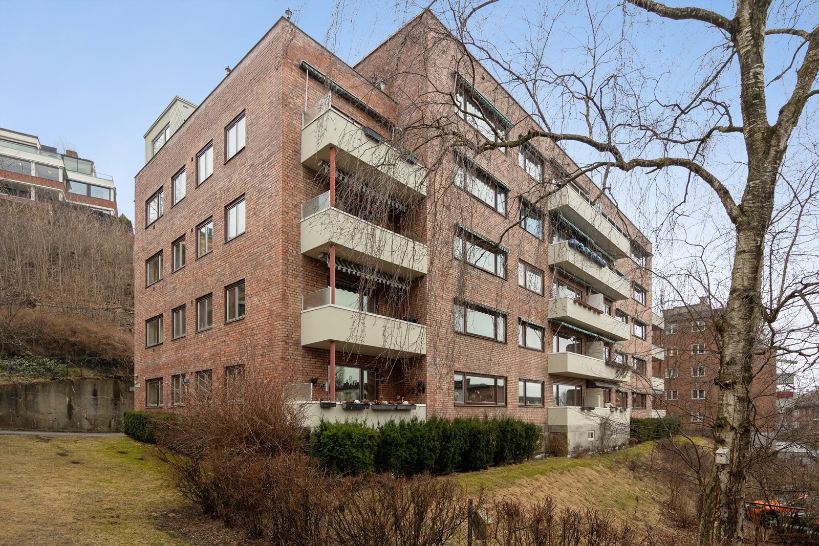 Klassisk teglbygård med balkonger og grønne fellesarealer i rolige, etablerte omgivelser. Galleribilde