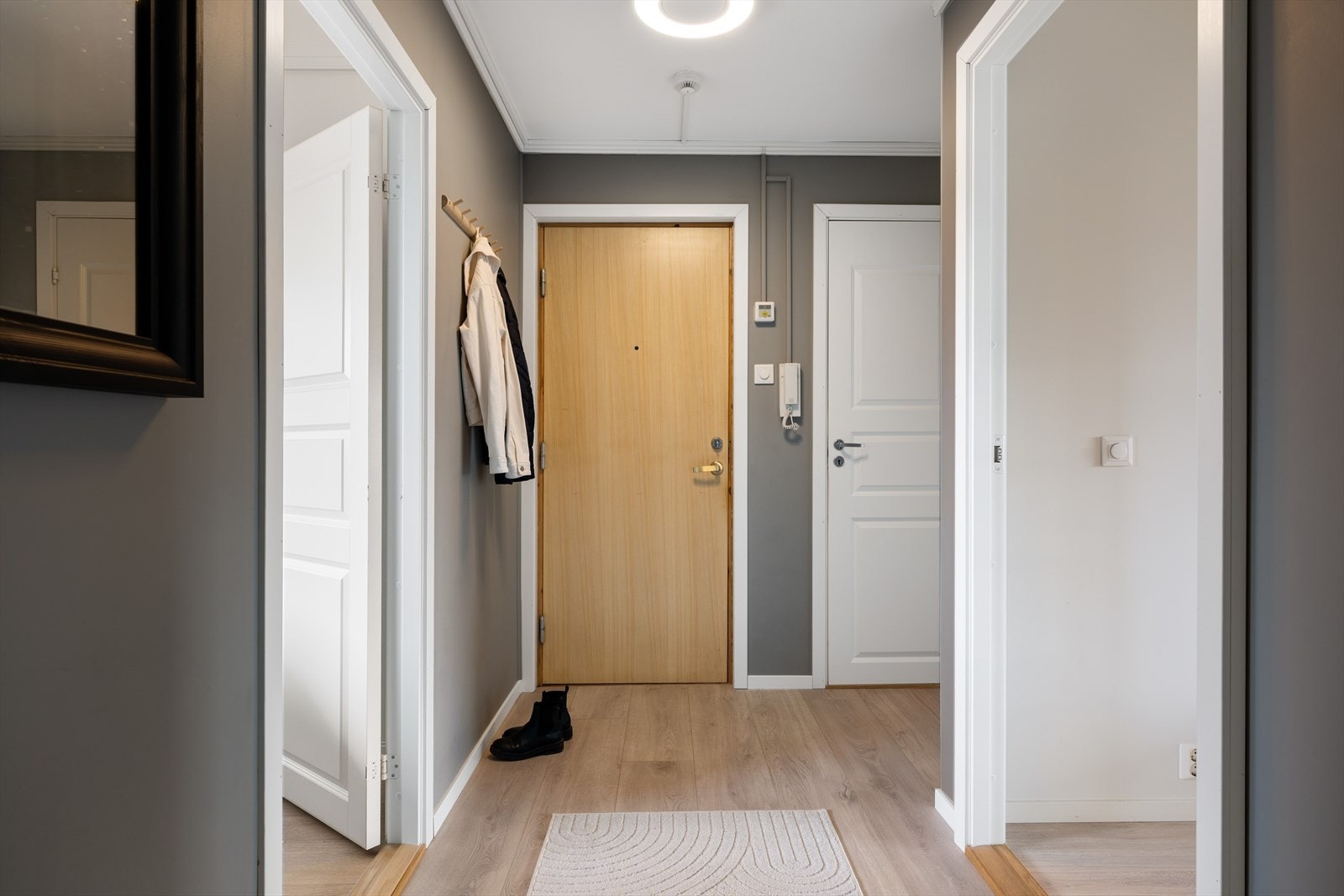 Forbi inngangsdøren venter en romslig og innbydende gang, som gir et svært godt førsteinntrykk i tillegg til å gi et frempek på hva som venter videre inn i leiligheten. Galleribilde