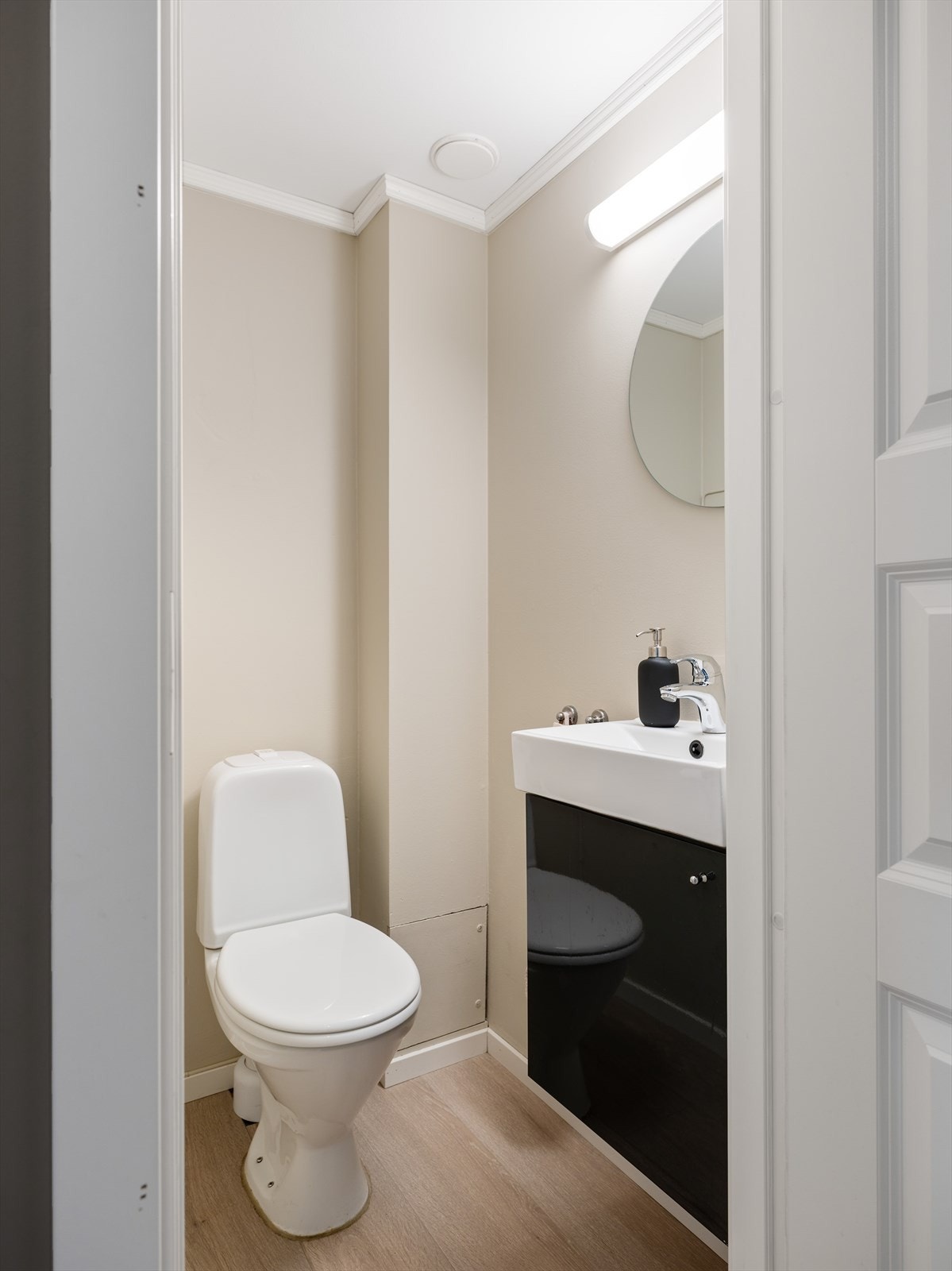 Toalettrommet ligger i nær tilknytning til bad, innredet med laminat på gulv og malte overflater på vegg. Rommet er videre utstyrt med toalett, baderomsinnredning og speil. Galleribilde