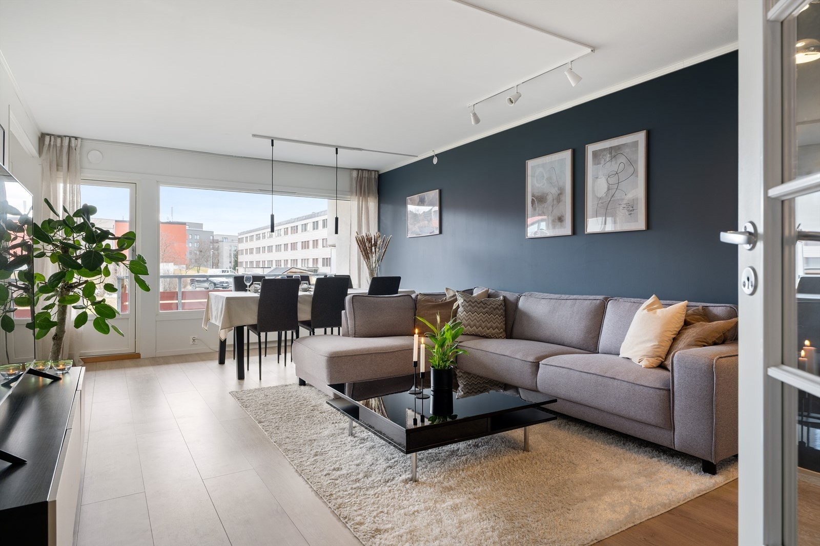 Stuen er generøs og har en spesielt god utforming der kjøkkenet ligger i en egen del, fremst i rommet. En dyp og lekker blåtone på veggene gjør seg særlig godt til gulvet som er lagt med 1-stavs laminat. Galleribilde