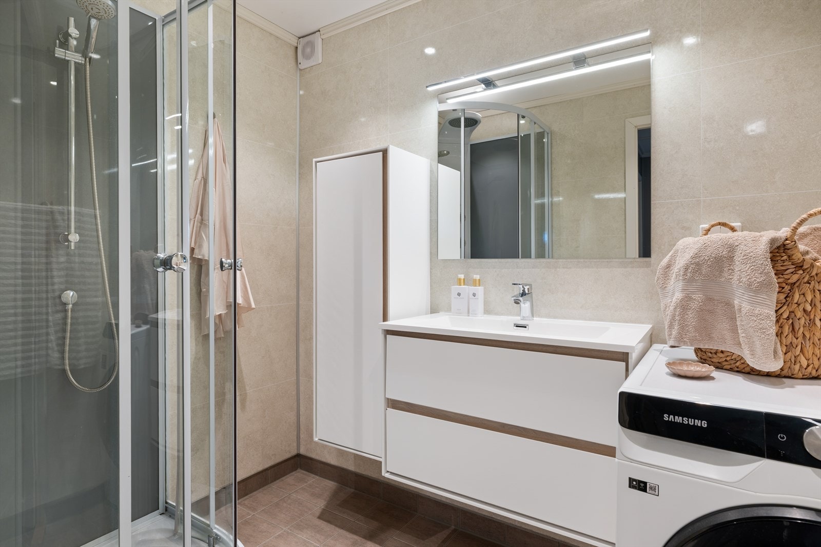 Boligen har et lekkert baderom med en tidsriktig og moderne utførelse. Her er det valgt mørke flis på gulv og lyse baderomsplater på vegg, for et eksklusivt velvære preg. Det hele forsterkes av velplasserte downlights i himling. Galleribilde