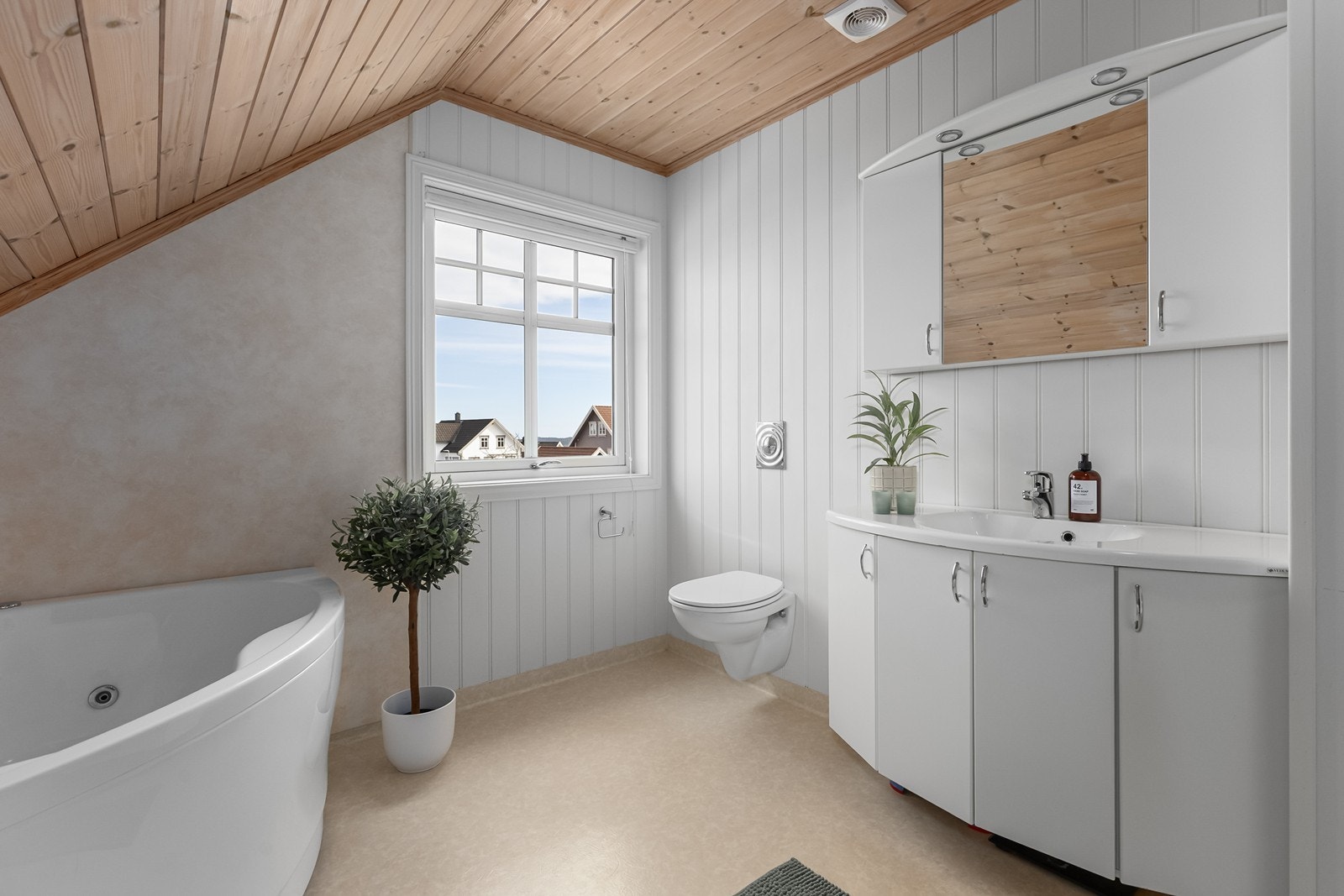 Badet er innredet med servant med skap og speil, vegghengt toalett, hjørneboblekar samt dusjhjørne Galleribilde