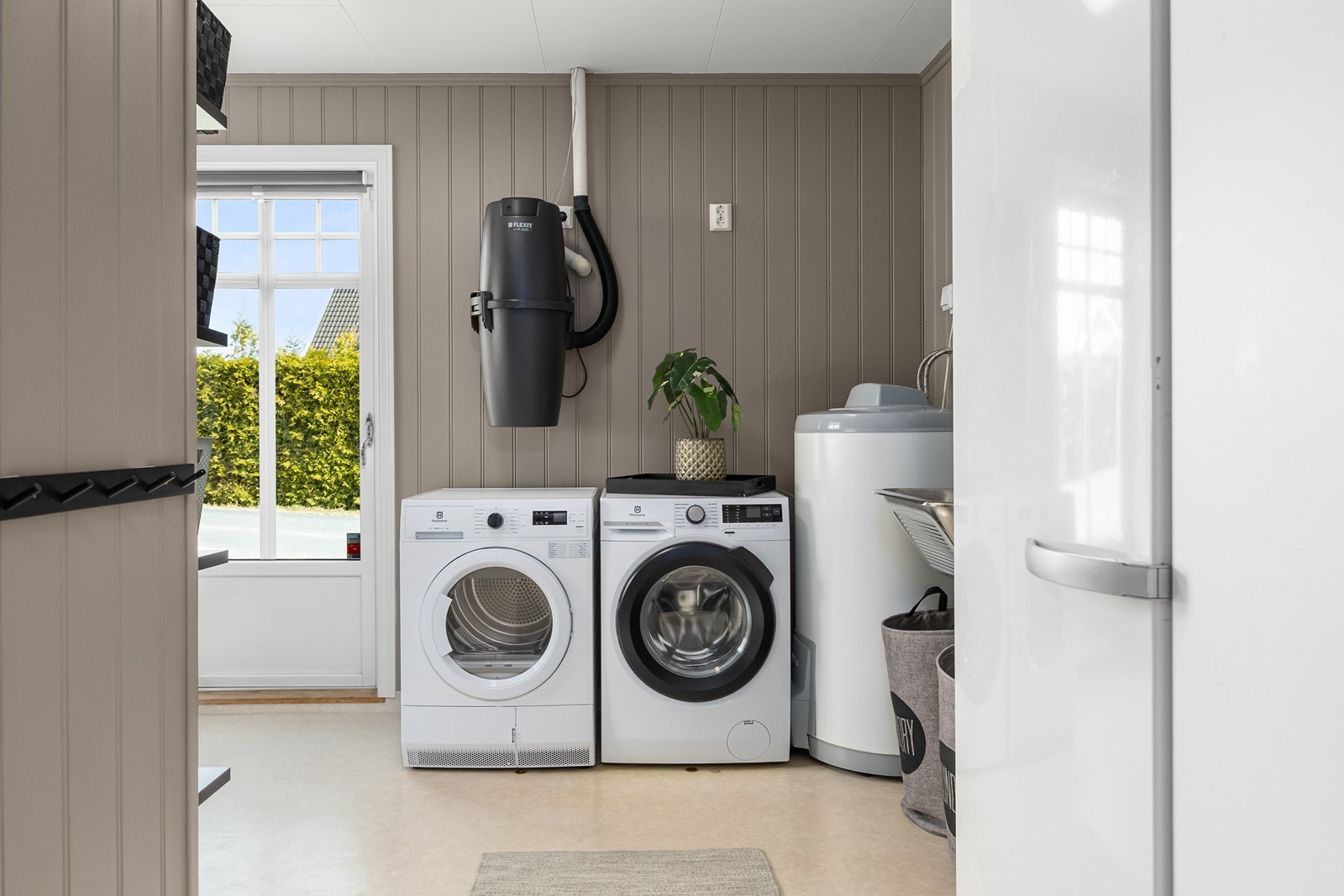 Vaskerommet er praktisk innredet med hyller og knagger, som byr på plass for oppbevaring Galleribilde