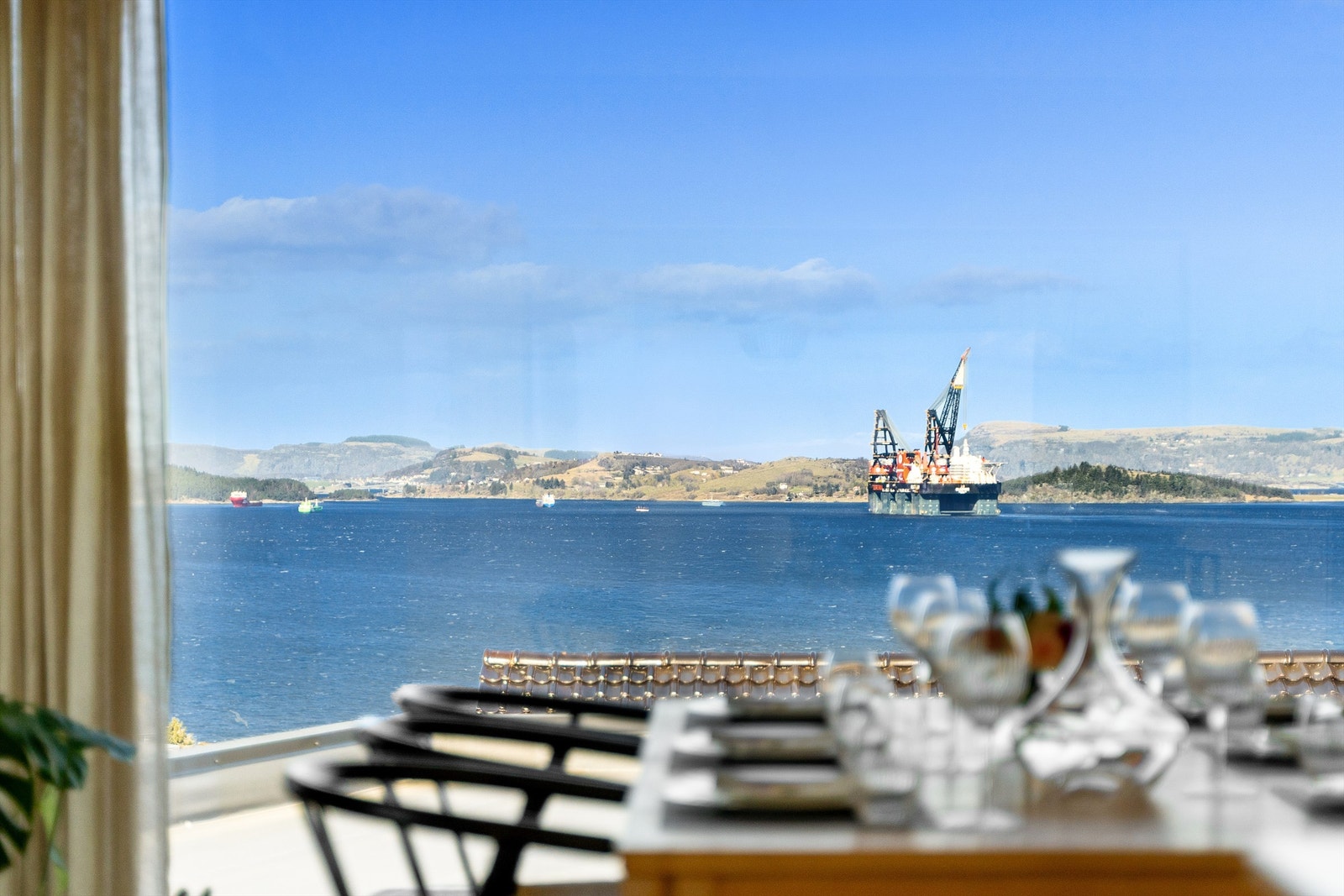 Stue har store vindusflater fra tak til gulv, som gir naturlig lysinnslipp og en god romfølelse. Galleribilde