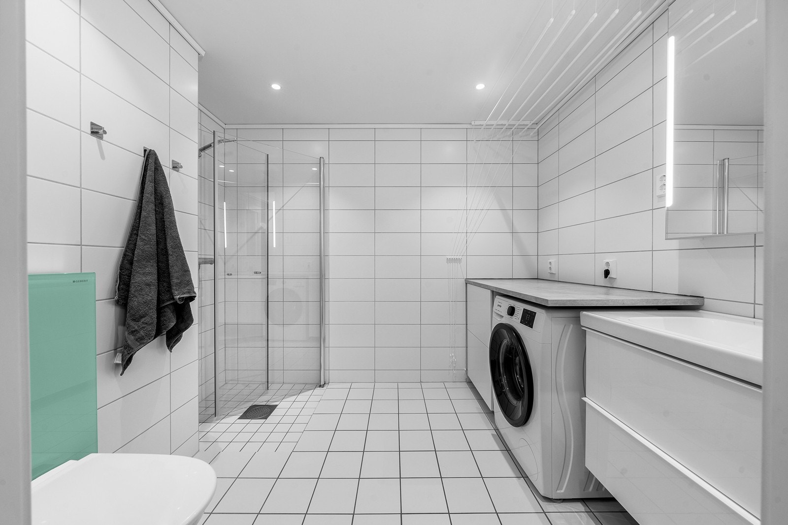 Romslig og helfliset bad med gulvvarme, downlights i taket og balansert ventilasjon. Galleribilde