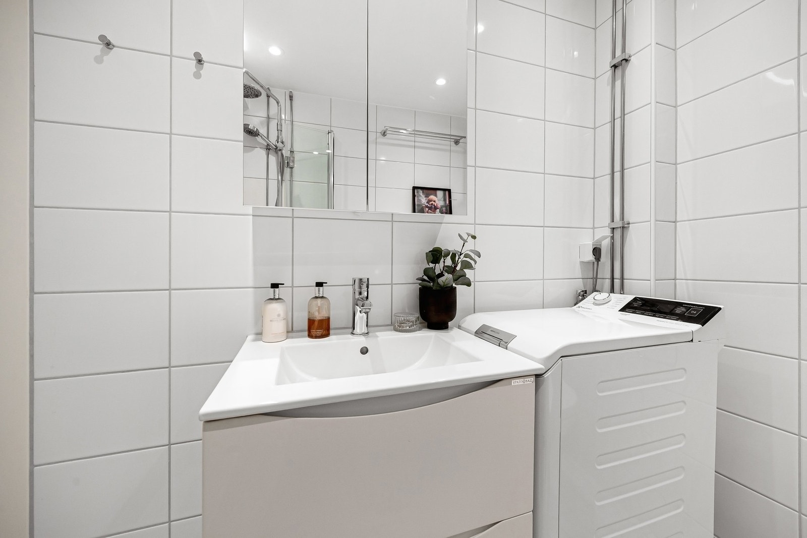 Baderommet har en 60cm bredt servantskap med glatte hvite skuffefronter og hvit keramisk servant Galleribilde
