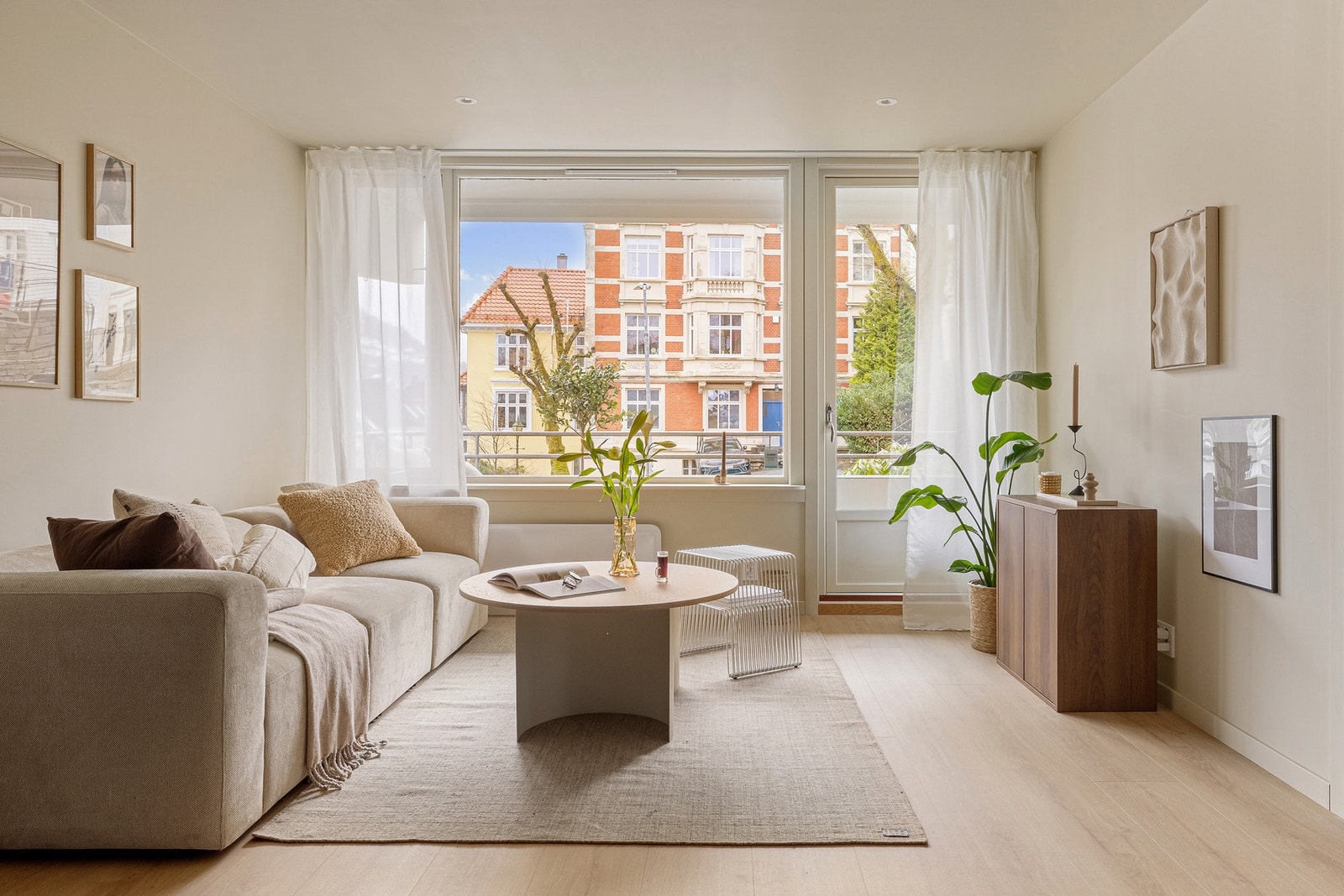 Vi beveger oss videre inn til hjertet av leiligheten, som er den lyse og moderne stuen med åpen kjøkkenløsning. Galleribilde