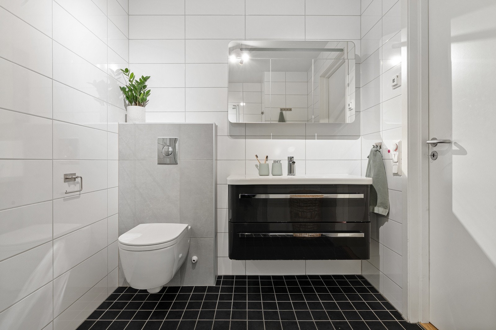 Flislagt hovedbad/wc med gulvvarme, vegghengt wc, baderomsinnredning med servant og speil