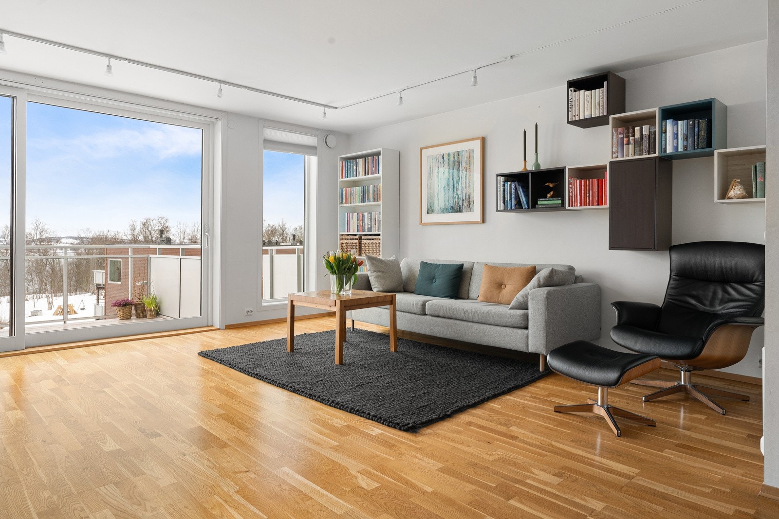 Lys og innbydende stue med høyt under taket og store vindusflater som gir rikelig med naturlig lys inn