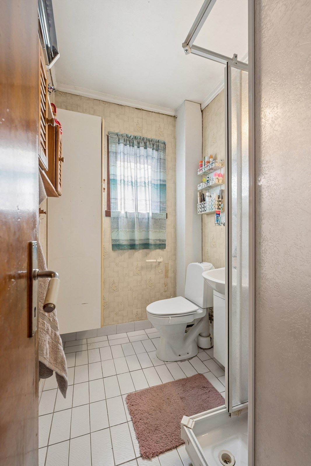 Badet i 2. etasje har flislagt gulv og våtromstapet på vegger. Innredet med servantinnredning med heldekkende servanttopp, speil og vegghengt skap. Dusjkabinett og toalett. Galleribilde