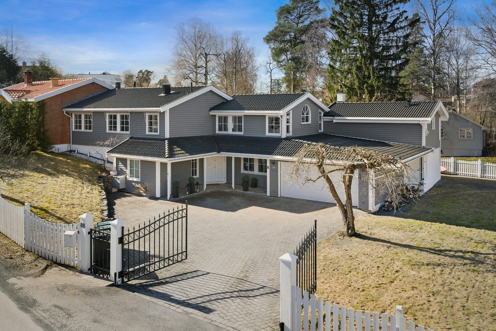 Belegningsstein på gårdsplass ved inngangsparti, garasjer og sideinngang til garasje. Stor gårdsplass med meget gode parkeringsforhold samt parkering i egen dobbelt garasje. inngang til sidefløy på andre siden av huset. Galleribilde