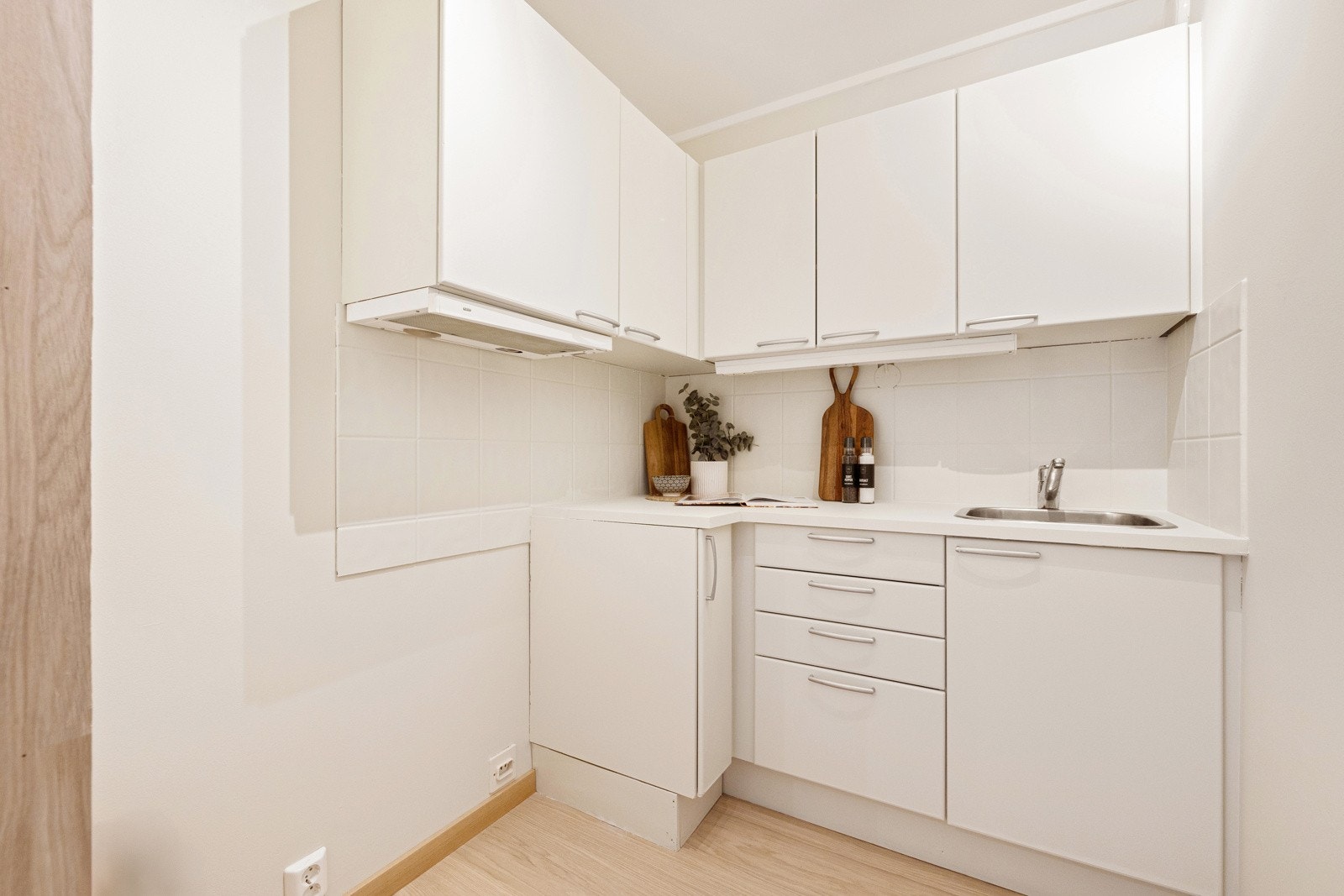 Lyst kjøkken med glatte fronter og laminat benkeplate. Galleribilde