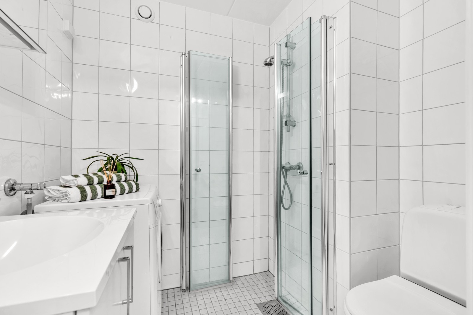 Flislagt bad med opplegg for vaskemaskin. Galleribilde