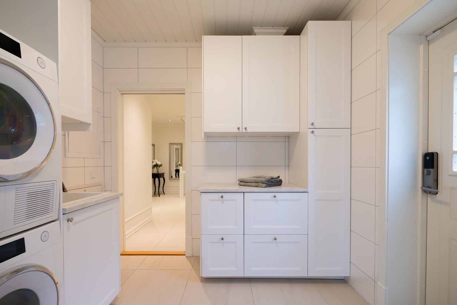 Vaskerommet er funksjonelt og elegant, med flislagte overflater og en praktisk skittentøyssjakt fra andre etasje, som gjør hverdagen enklere og mer effektiv. Galleribilde
