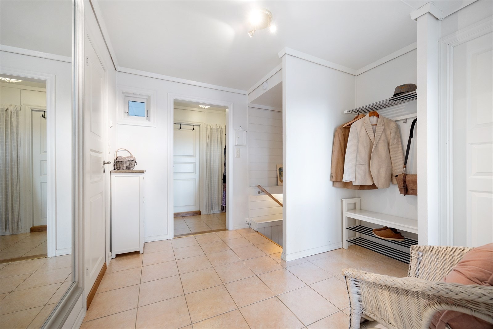 Entré og hall med fliser på gulv og lyse veggflater. Plass til å henge opp yttertøy Galleribilde