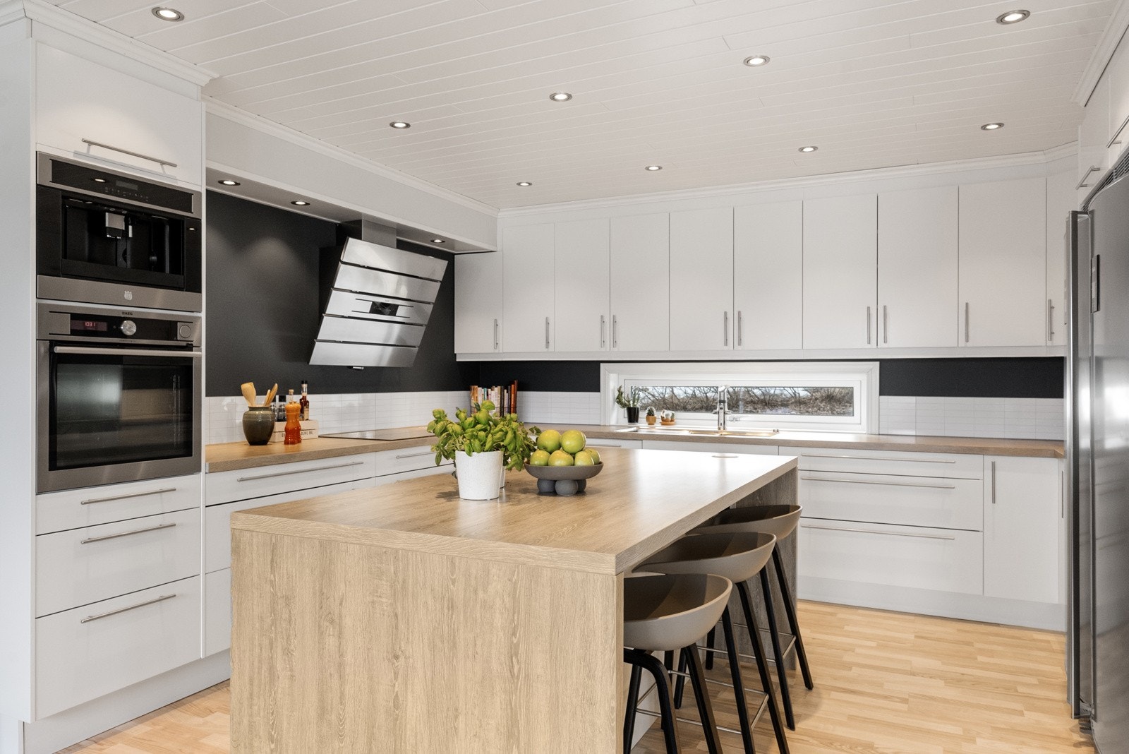 Kjøkkeninnredning med laminerte skrog og glatte fronter. Laminert benkeplate. Galleribilde