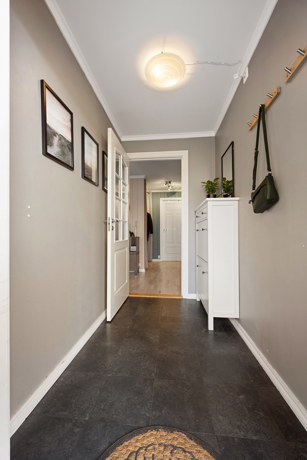 I entréen er det belegg på gulv (lagt over terrakottafliser), malte overflater på vegger og malt himling. Den lyse fargepaletten bidrar til et helhetlig og tiltalende uttrykk. Galleribilde