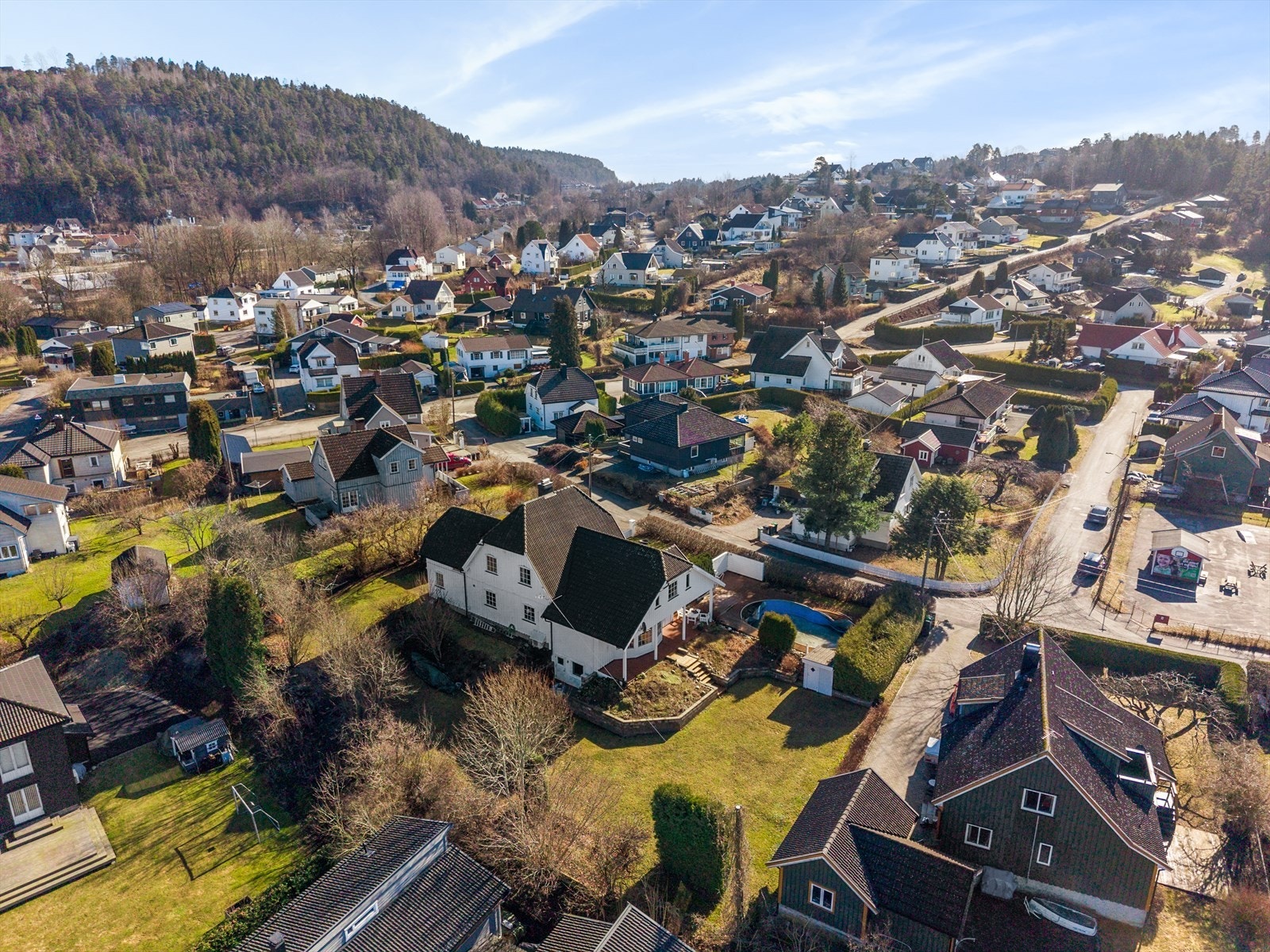 Terrassen strekker seg langs to sider av boligen, og frem til et stort og solrikt uteområde med terrasseplatting og basseng. Galleribilde