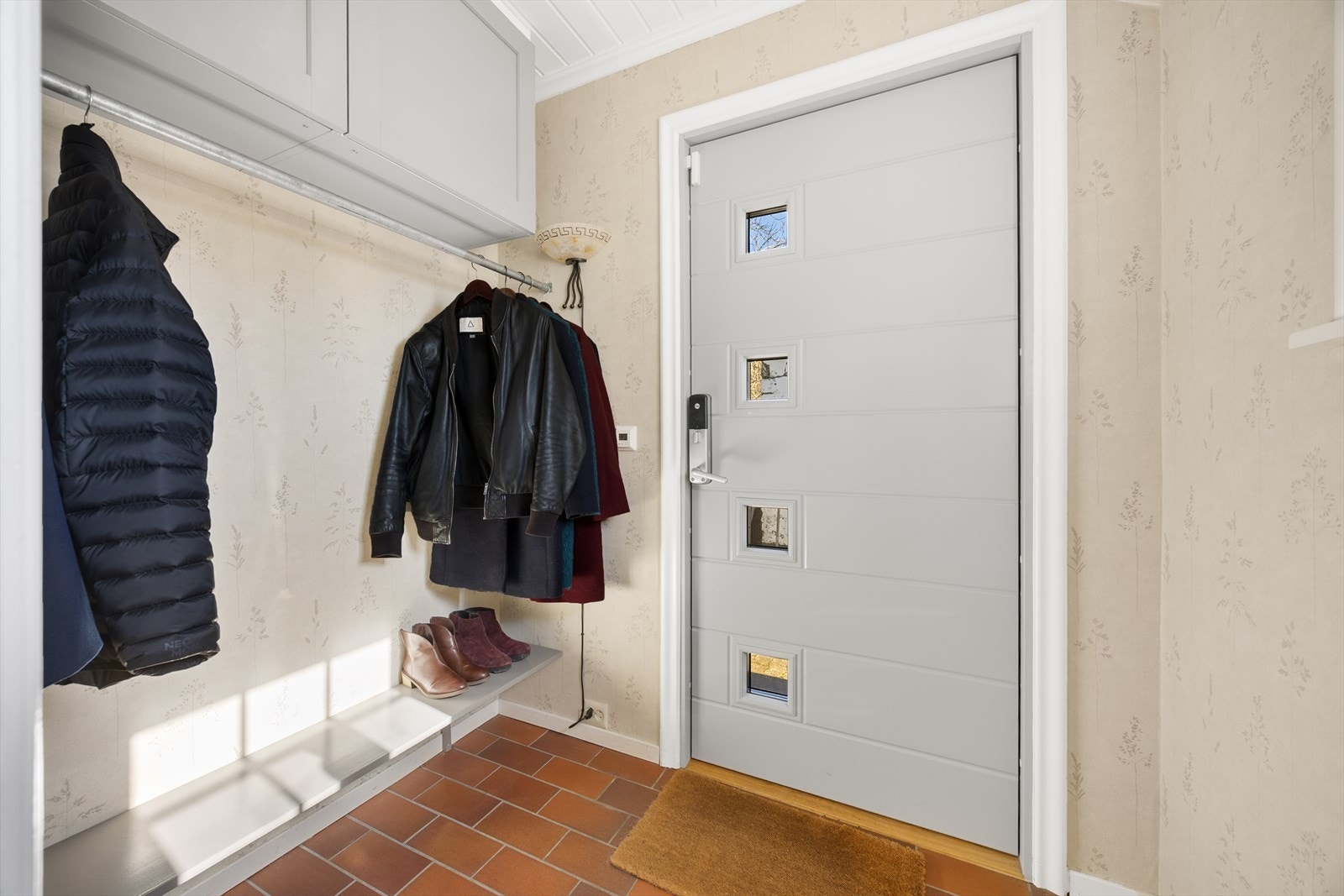 Trivelig entré som ønsker velkommen inn i boligen, hvor det er plassbygget skap på vegg samt skohylle og heng. Her er det god plass til sko og yttertøy. Galleribilde