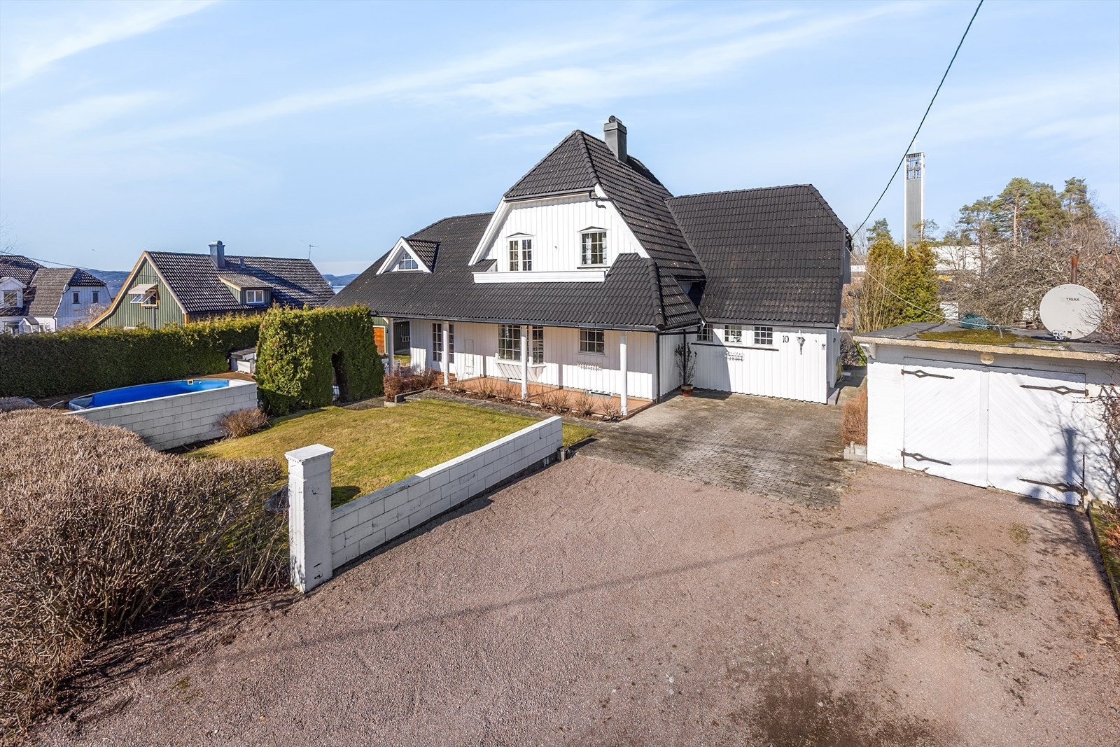 Romslig, gruset gårdsplass med flere biloppstillingsplasser, samt eldre garasje. Galleribilde
