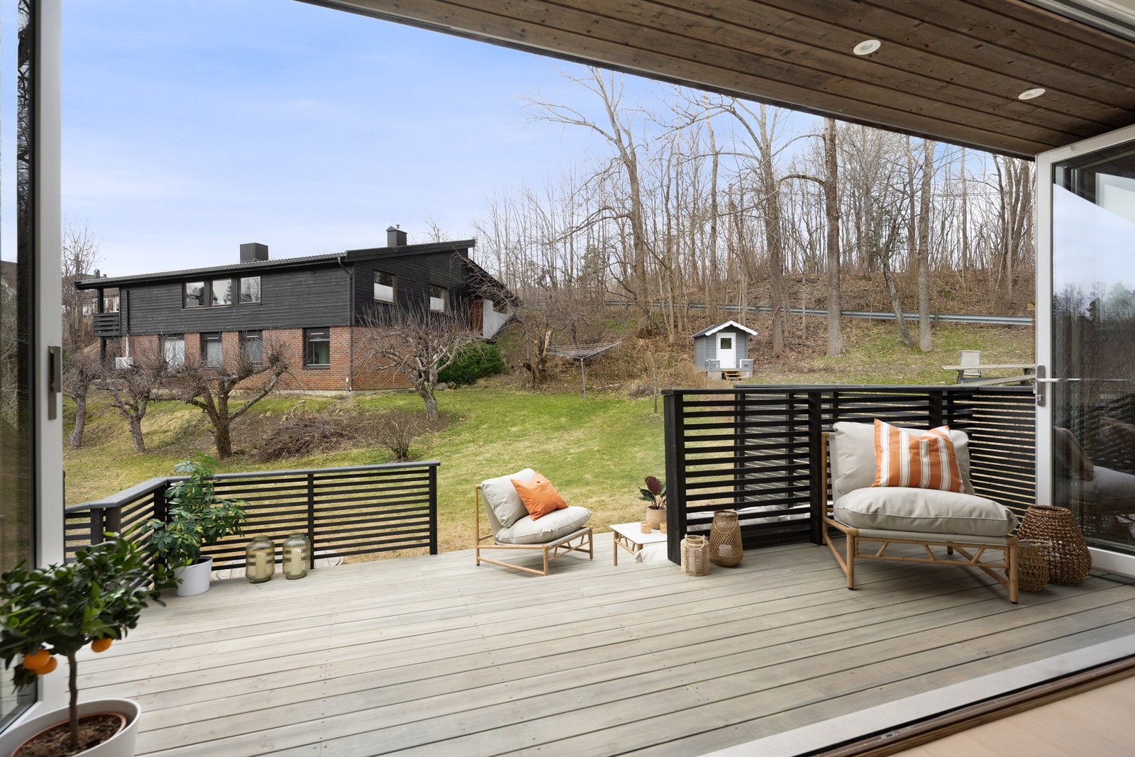 Stor, overbygd terrasse med god plass til sittegruppe og utsyn mot hagen. Galleribilde