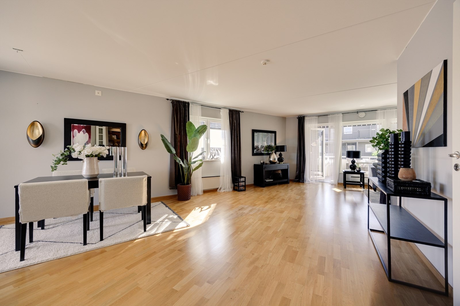 En lys og innbydende stue med store vindusflater som slipper inn rikelig med dagslys fra flere kanter og skaper en luftig og behagelig atmosfære. Galleribilde