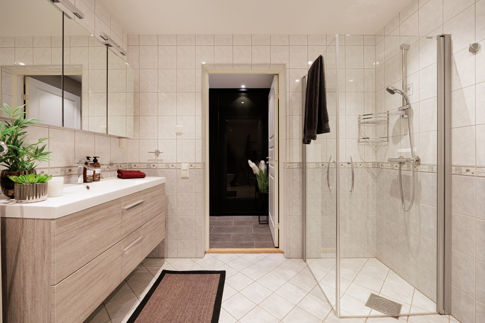 Innredningen på badet består av benkeskap med glatte fronter og veggskap med speil. Galleribilde