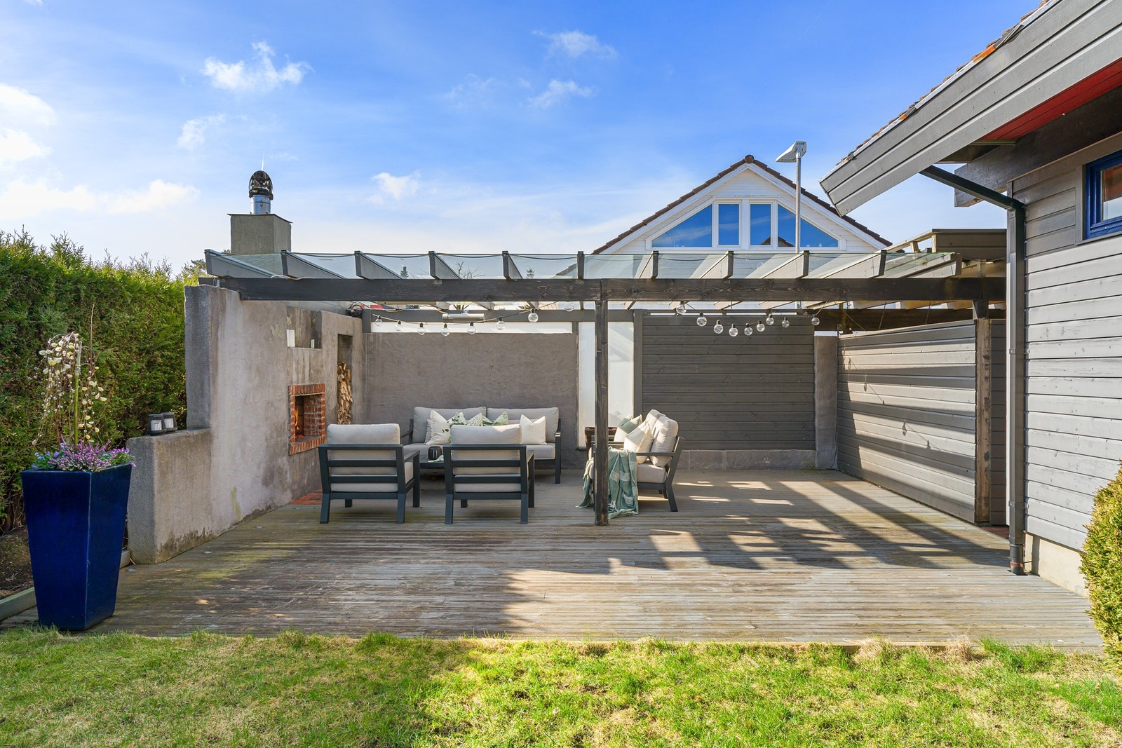 Uteområdet består av plen, terrasse og en innbydende utestue med peis, som gir ekstra brukstid gjennom året. Galleribilde