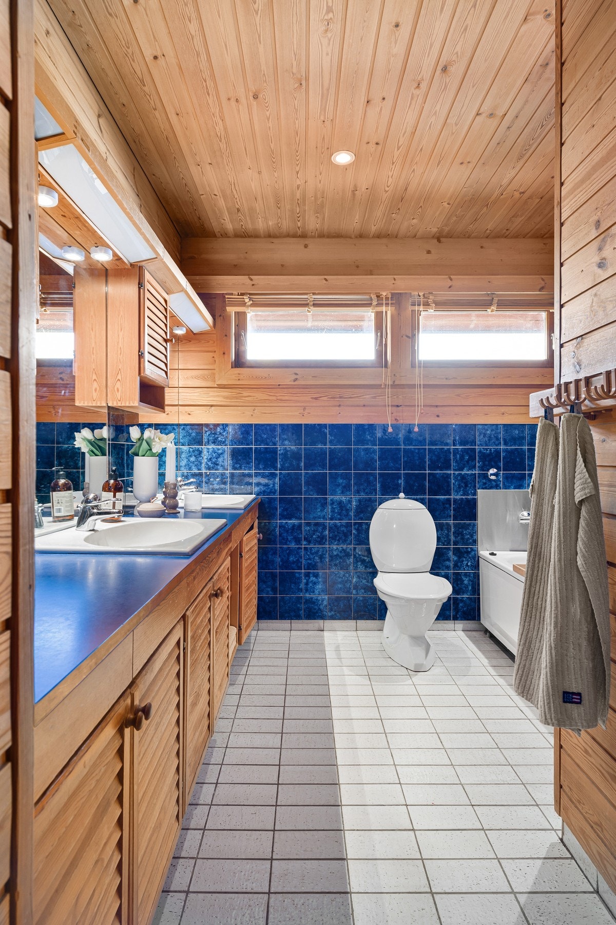 Badet i først etasje har fliser på gulv, samt fliser og trepaneler på vegger. Galleribilde