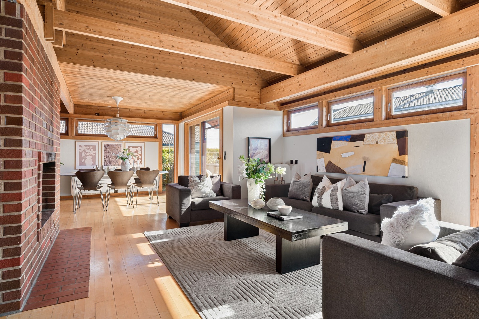 Stue med gjennomgående bruk av treverk og synlige bjelker som gir et lunt preg. Galleribilde