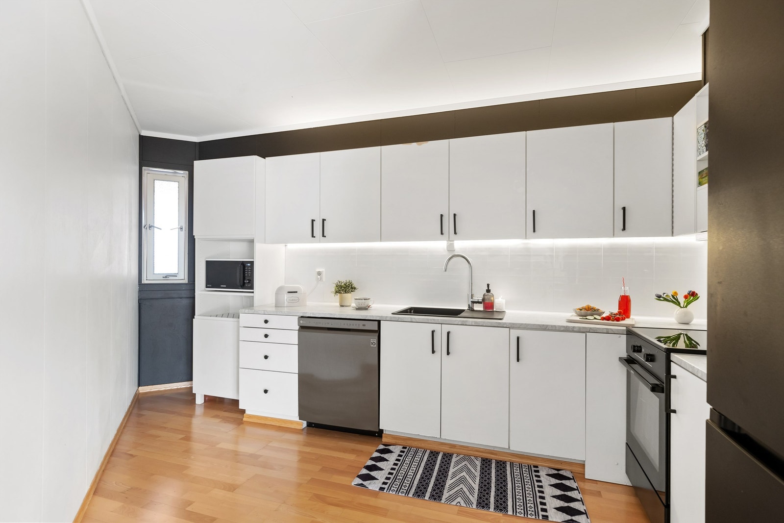 Kjøkkenet har en funksjonell innredning med glatte fronter og laminert benkeplate. Galleribilde